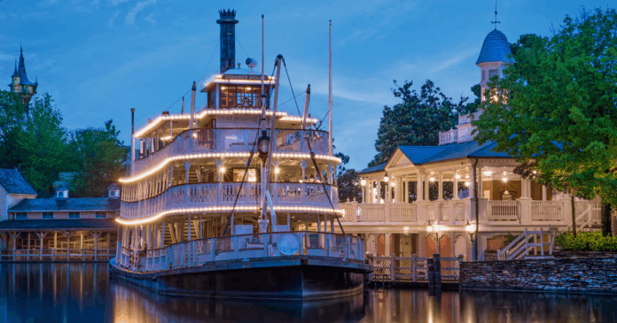 The Liberty Square Riverboat illuminated at night on the Rivers of America, symbolizing the iconic area's upcoming closure for future development.